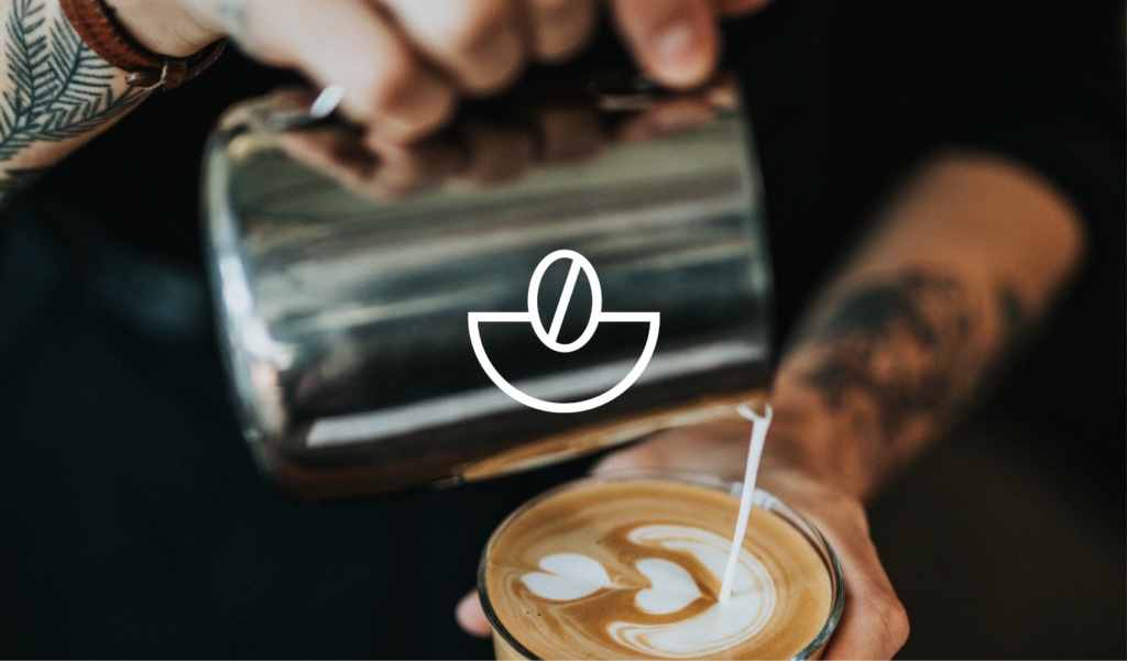 Grounded Coffee logo over image of barista pouring milk into coffee